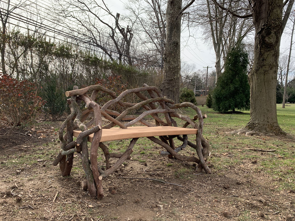 Outdoor rustic park bench built using mountain laurel trees and branches titled the Mountain Laurel Bench