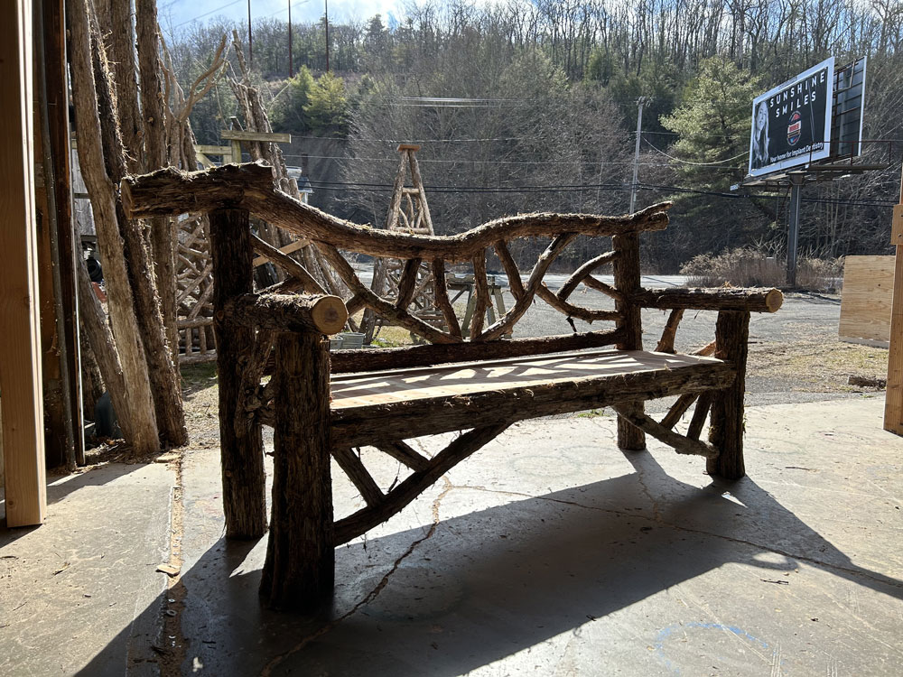 Outdoor rustic garden bench built using bark-on trees and branches titled the Evans Bench