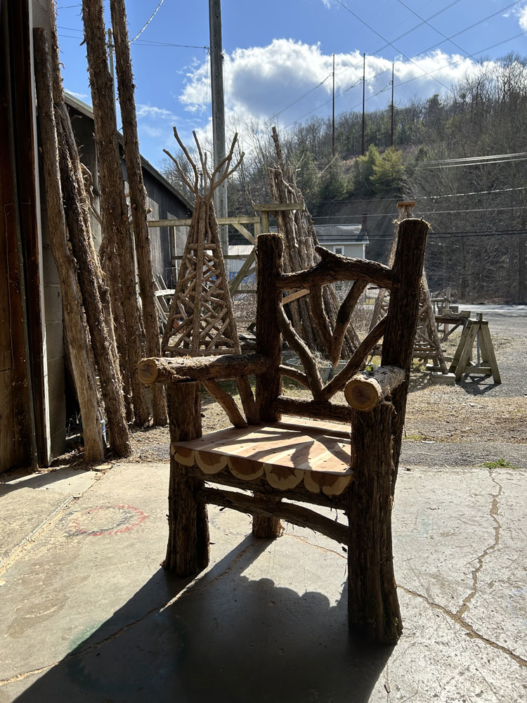 Outdoor rustic garden chair built using bark-on trees and branches titled the Evans Chair