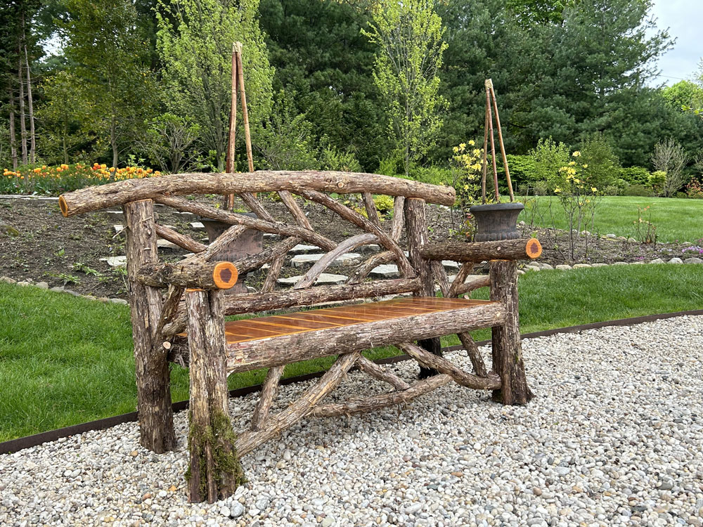 Exterior twig bench built from cedar logs titled the Rhinebeck Bench