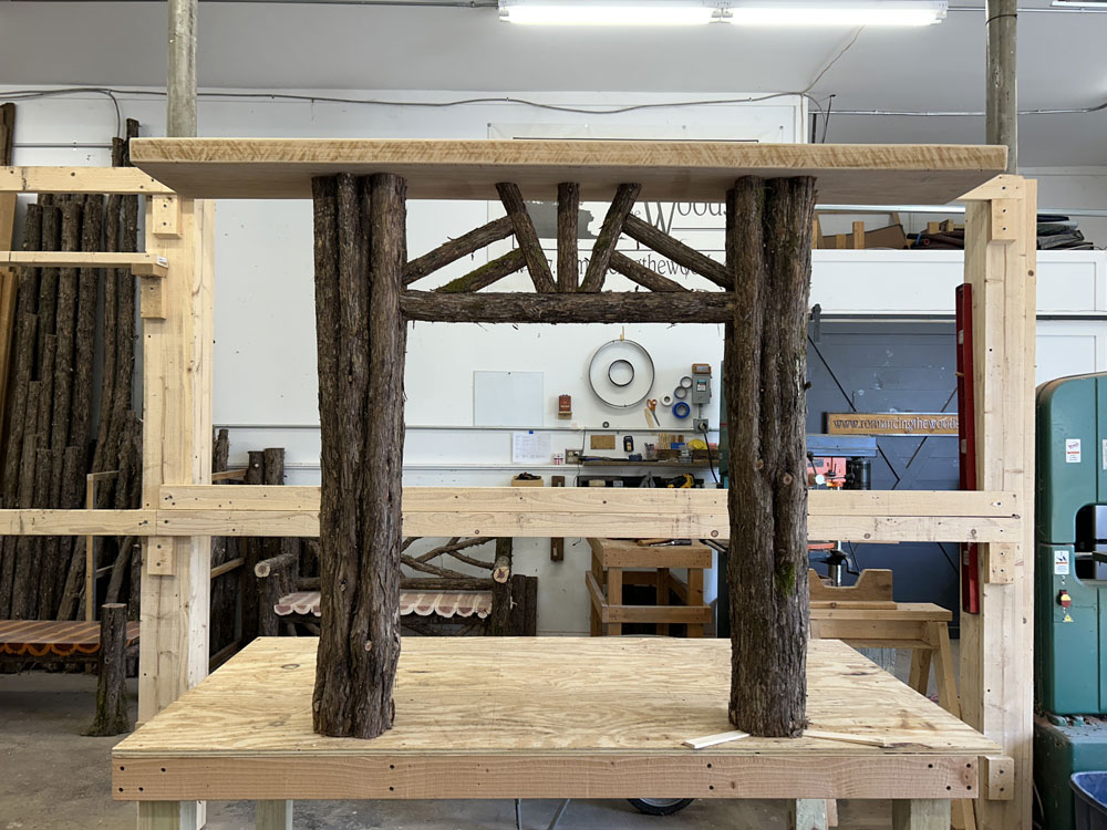 Rustic bench custom built using cedar trees and branches titled the White Lake Bench