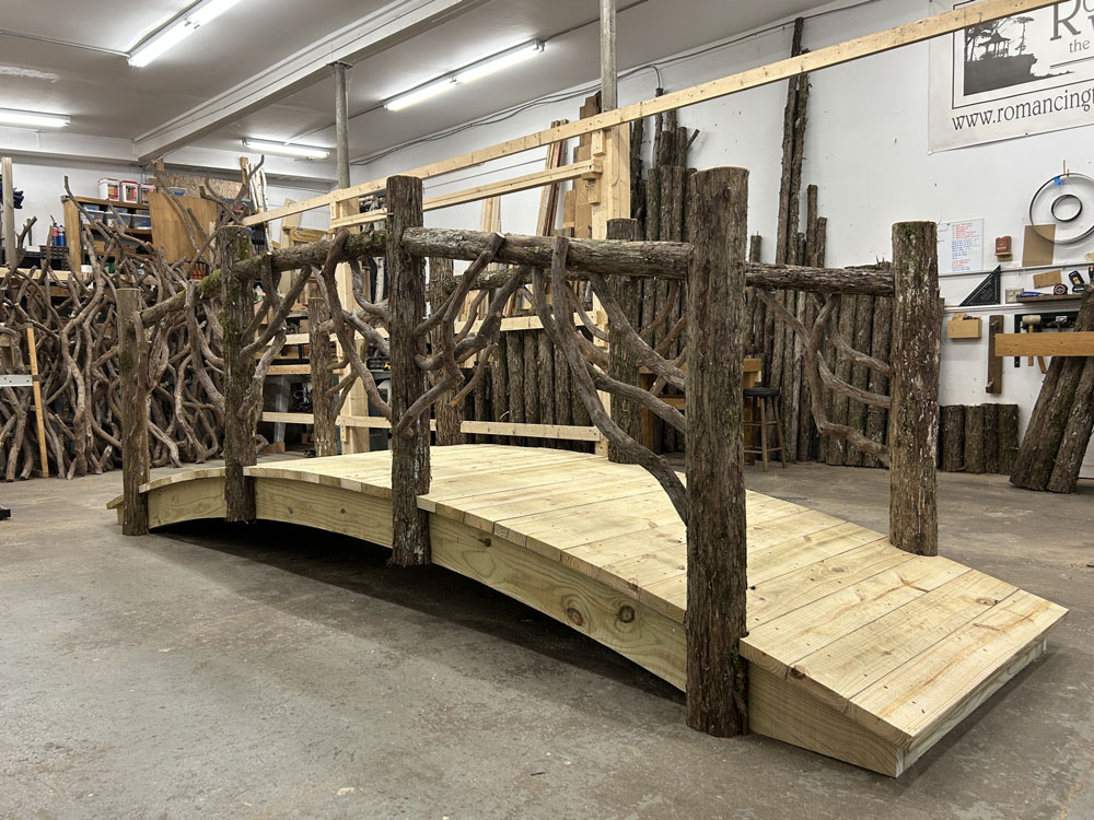 Rustic bridge custom built using cedar trees and branches titled the White Lake Bridge