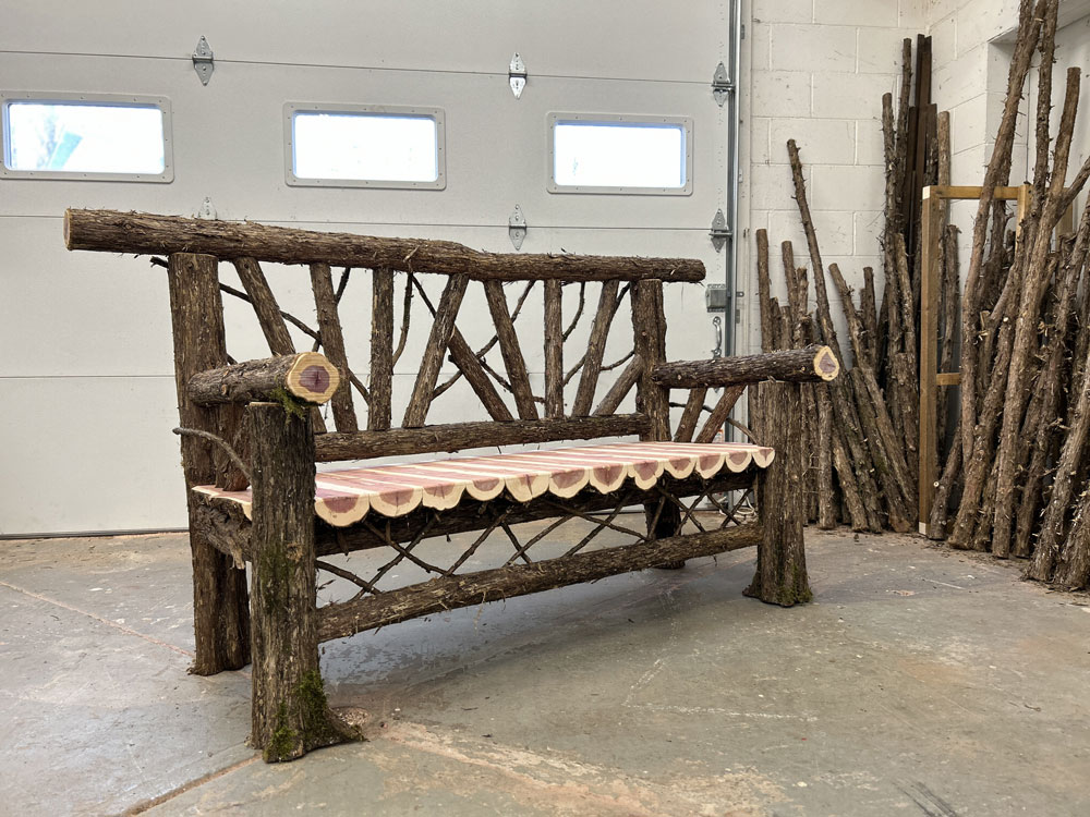 Outdoor rustic garden bench built using bark-on trees and branches titled the Sugar Bench