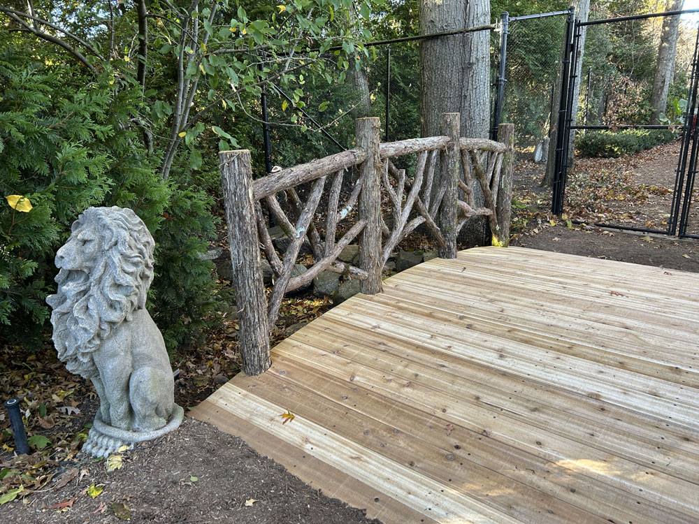 Rustic bridge custom built using cedar trees and branches titled the Tyson Bridge