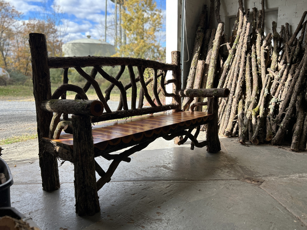 Outdoor rustic park bench built using eastern red cedar and mountain laurel trees and branches titled the Mohonk Bench