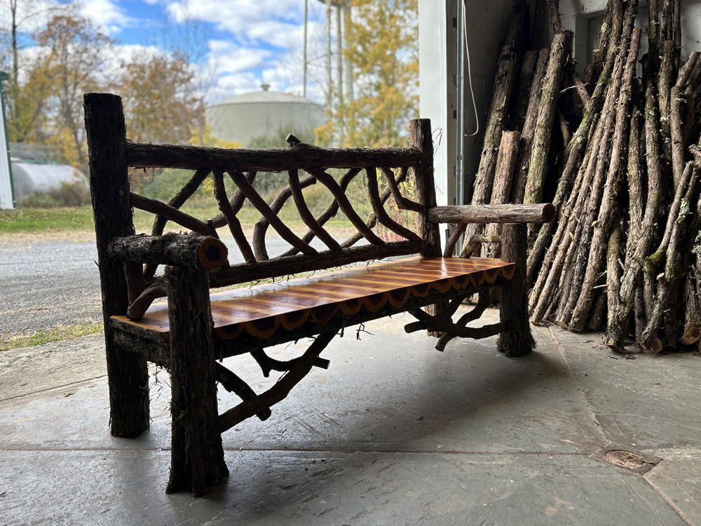 Outdoor rustic park bench built using eastern red cedar and mountain laurel trees and branches titled the Mohonk Bench