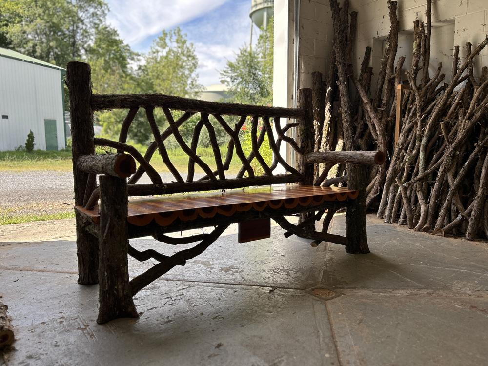 Rustic bench custom built using cedar trees and branches titled the Mohonk Bench
