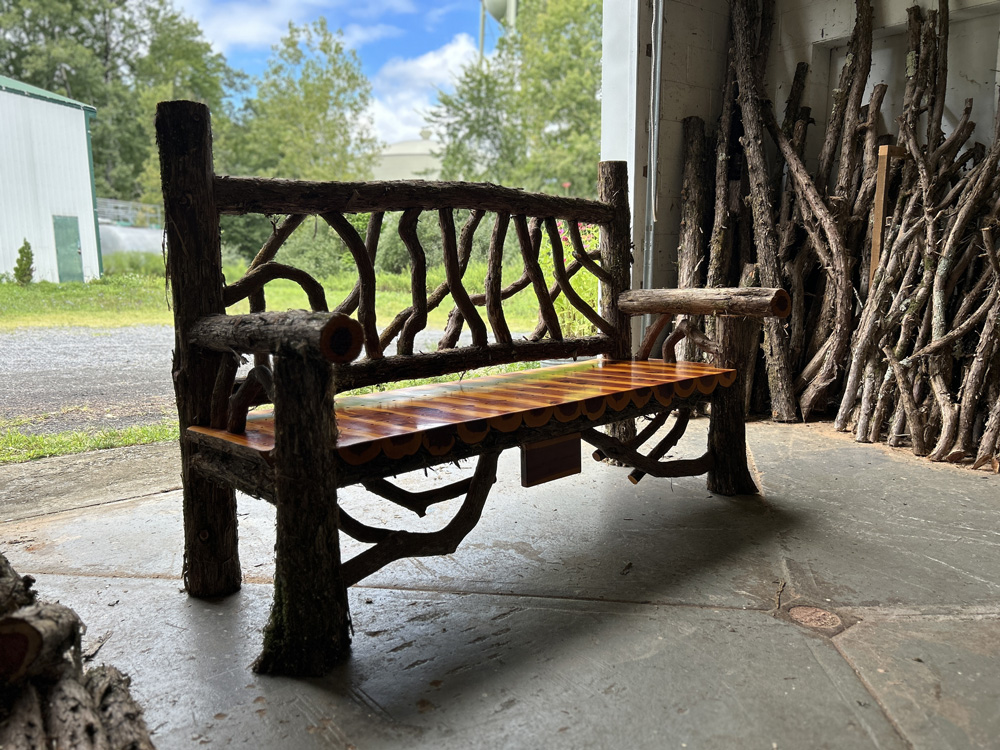 Natural wood bench built with trees and branches titled the Mohonk Bench