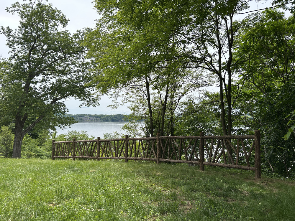 Rustic garden fencing built using bark-on trees and branches titled the Rhinecliff Poet's Fencing
