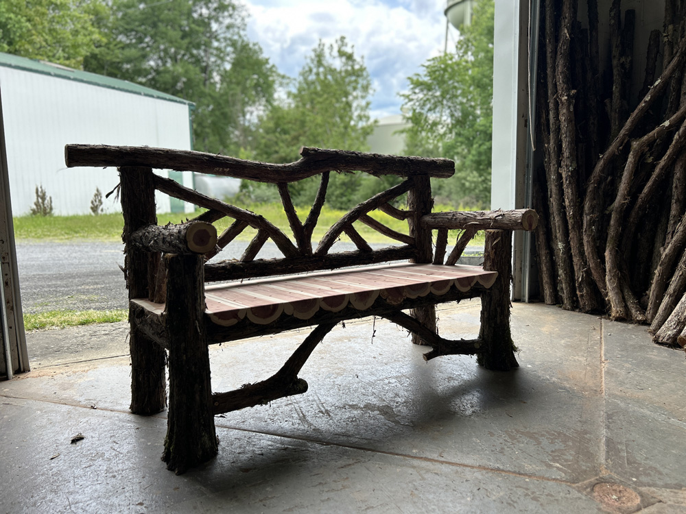 Natural wood bench built with trees and branches titled the Butterfly Bench
