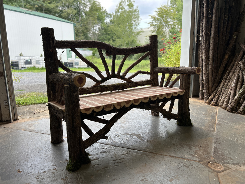Exterior twig bench built from cedar logs titled the Sunburst Bench
