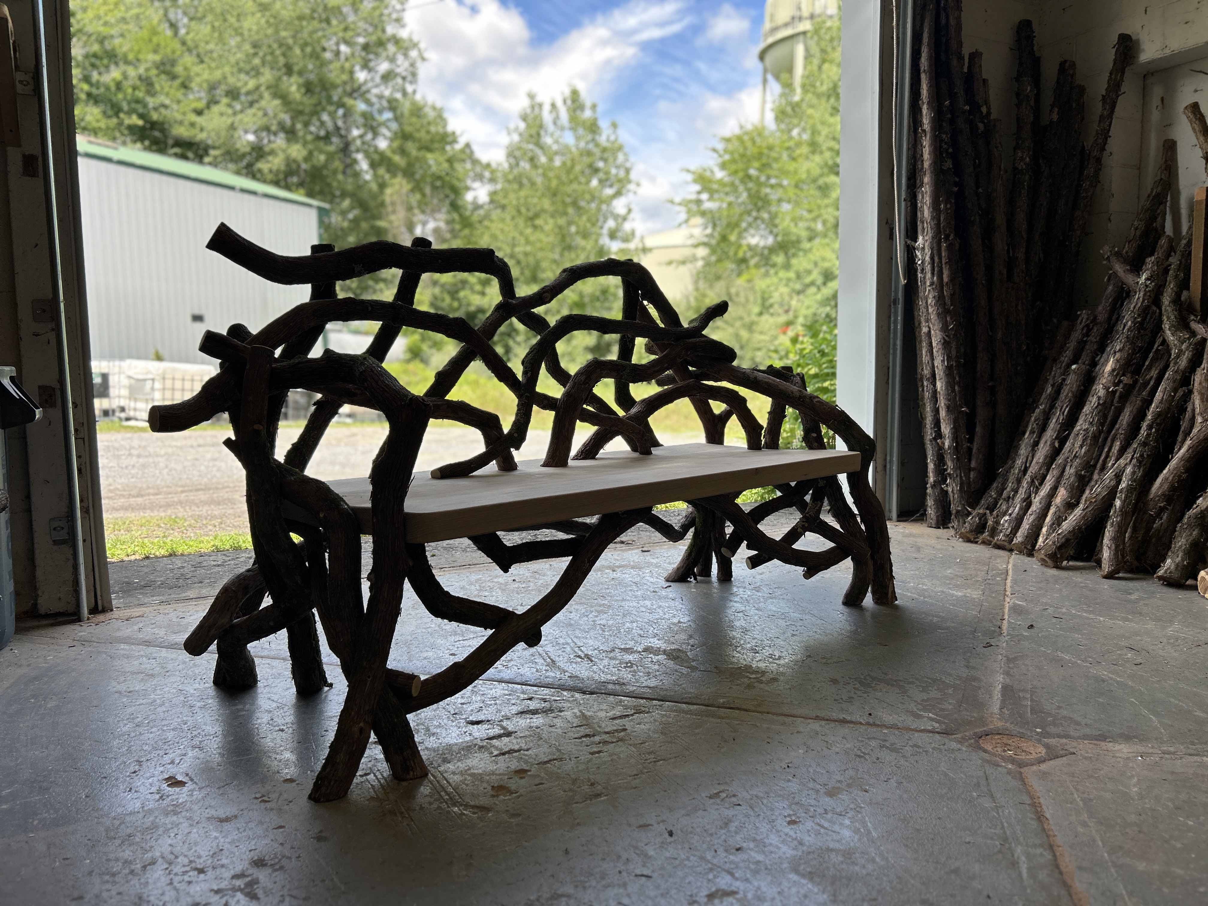 Outdoor rustic park bench built using mountain laurel trees titled the Olana Bench