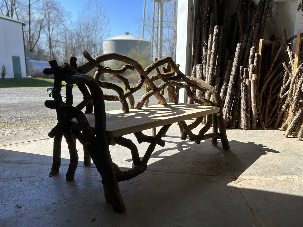 Outdoor rustic park bench built using mountain laurel trees titled the Olana Bench