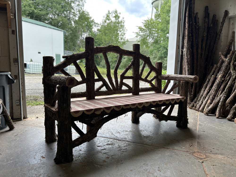Natural wood bench built with trees and branches titled the Butterfly Bench