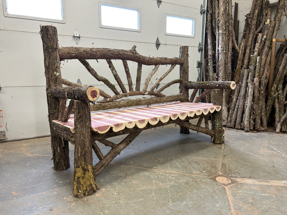 Outdoor park bench built in the rustic style using logs and branches titled the Millbrook Sunburst Bench