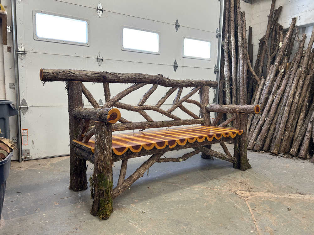 Outdoor park bench built in the rustic style using logs and branches titled the Millbrook Sunburst Bench