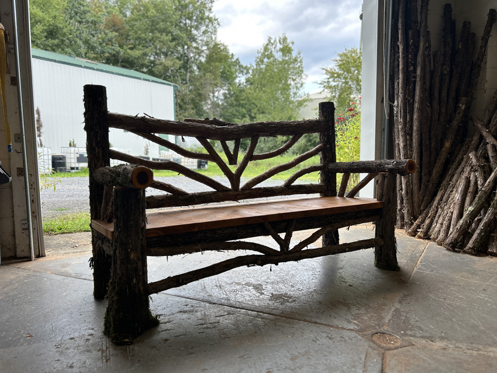 Natural wood bench built with trees and branches titled the Delhi Bench