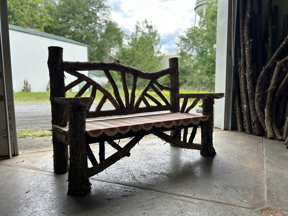 Outdoor rustic park bench built using eastern red cedar and mountain laurel trees and branches titled the Taconic Bench