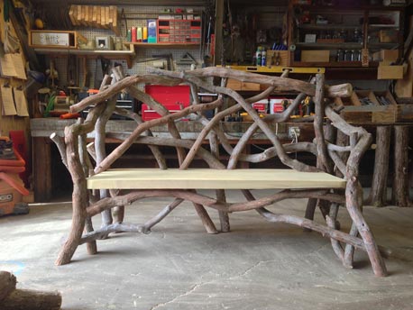 Outdoor rustic bench constructed using bark-on trees and branches built for Columbia County Land Conservancy.