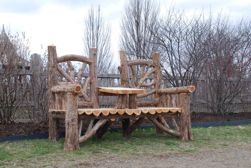 Rustic bench swing custom built using cedar trees and branches titled the Midler Couples Bench