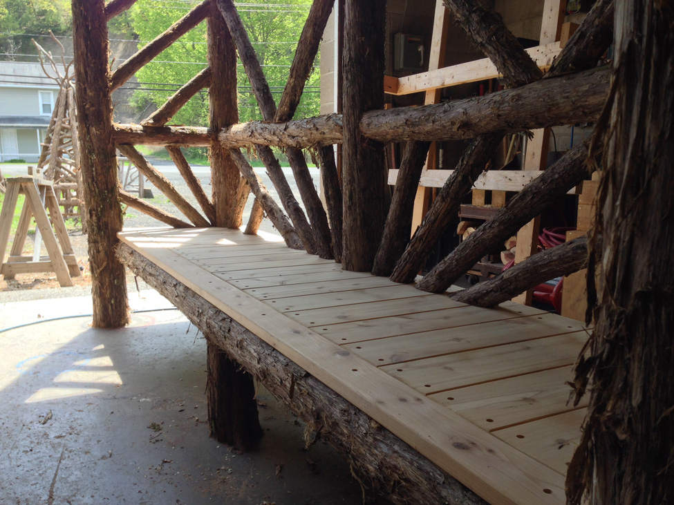 Outdoor rustic covered bench built using bark-on trees and branches titled the Skyview Entrance Arbor