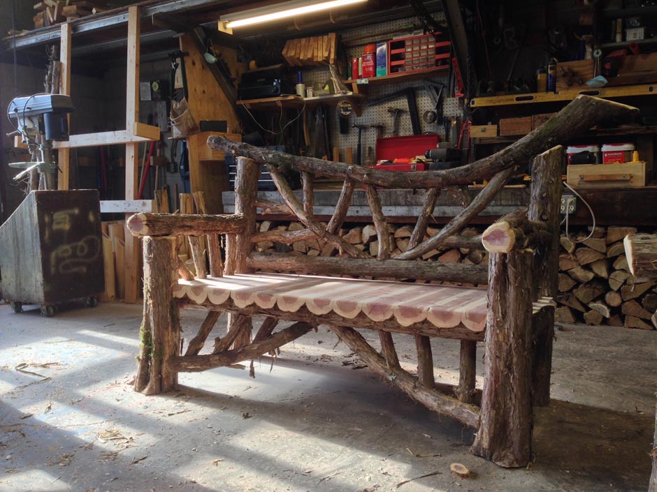Rustic bench custom built using cedar trees and branches titled the Midler Falling Waters Bench