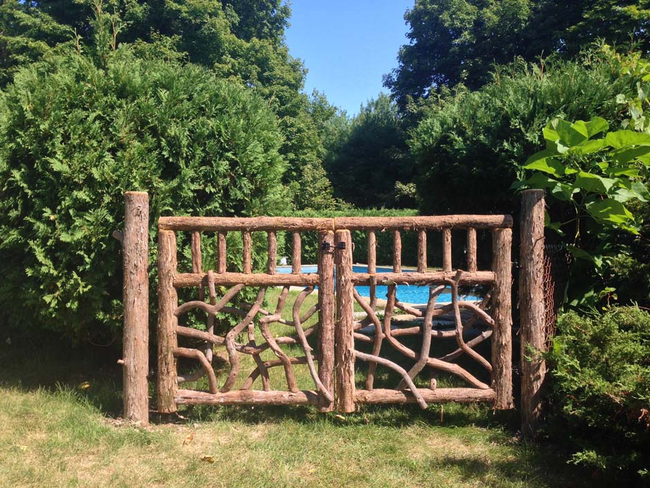 Rustic gates built using bark-on trees and branches titled the Palenville Gates