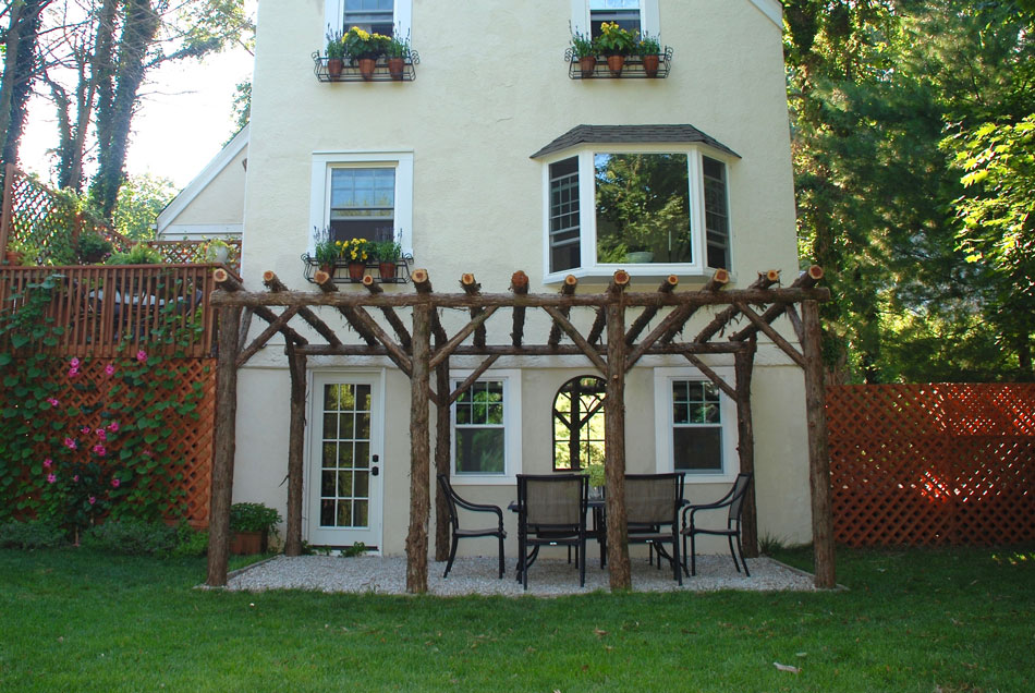 Natural wood rustic pergola built with trees and branches titled the Larchmont Pergola