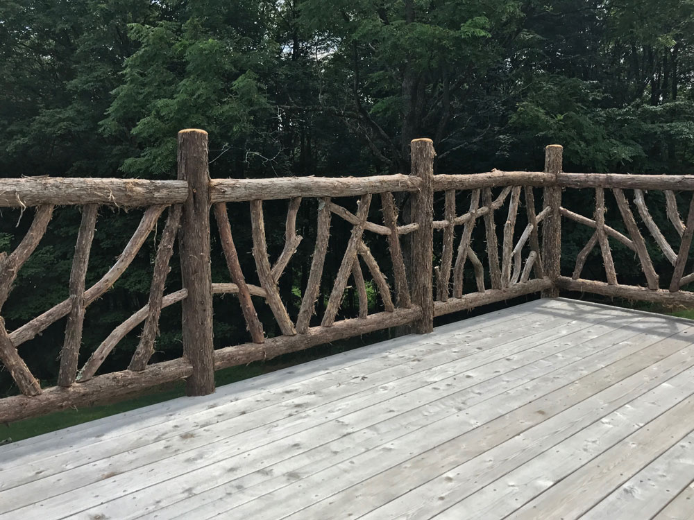 Natural wood deck railings built with trees and branches titled the Burroughs Deck Railings