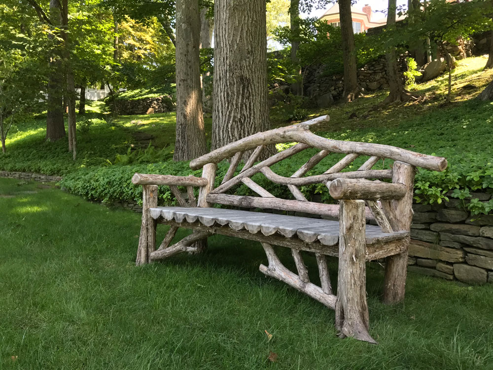Outdoor park bench built in the rustic style using logs and branches.