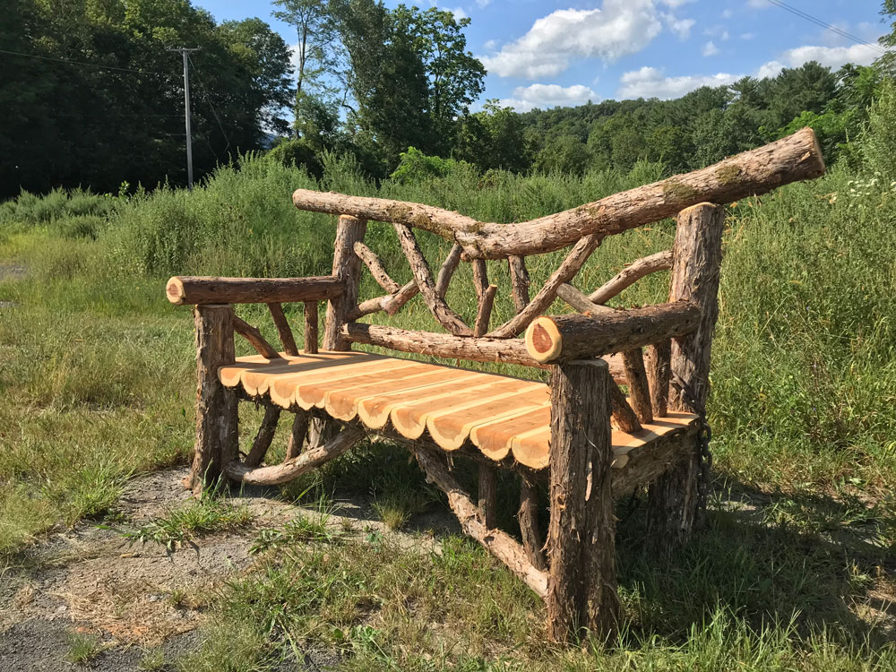 Exterior twig bench built from cedar logs.