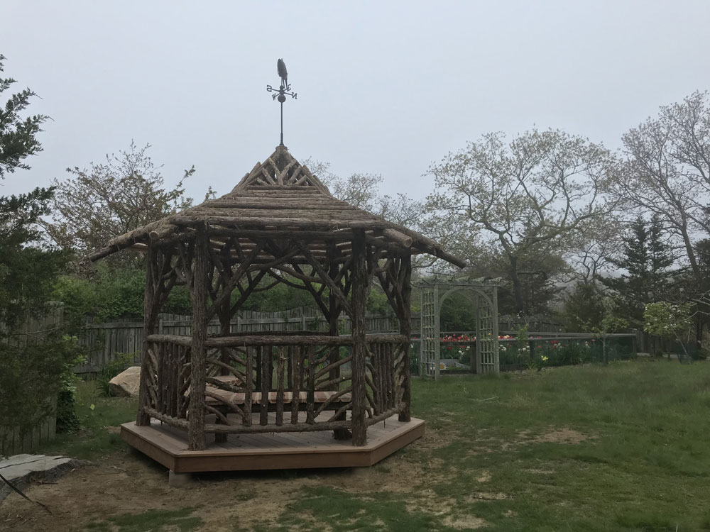 Rustic gazebo built in the rustic style using logs and branches titled the Fishers Island Gazebo