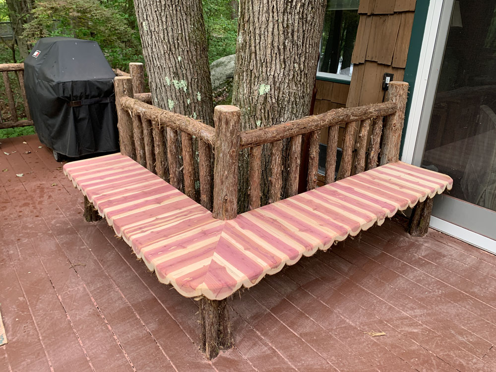 Deck railings built in the rustic style using logs and branches titled the Holmes Deck Bench
