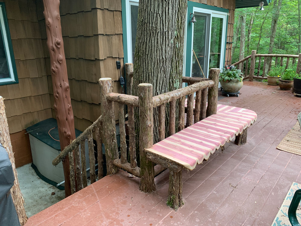 Natural wood deck railings built with trees and branches titled the Holmes Deck Bench