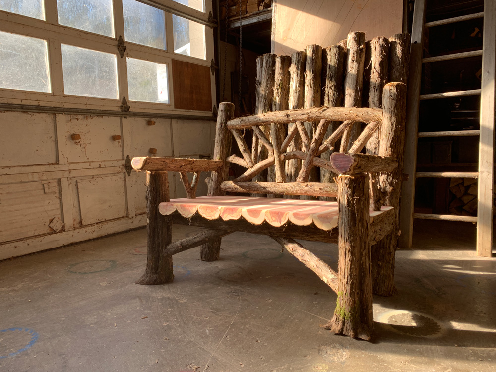 Exterior twig bench built from cedar logs titled the 4' Maverick Bench