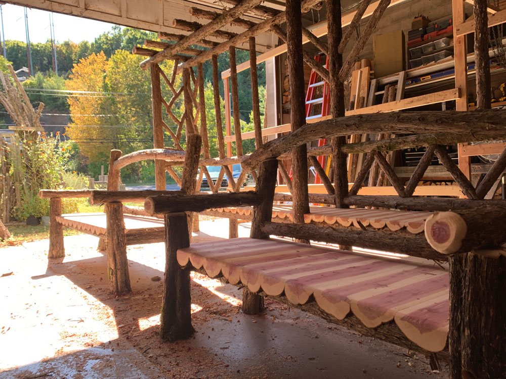 Rustic bench custom built using cedar trees and branches titled the Poet's Bench