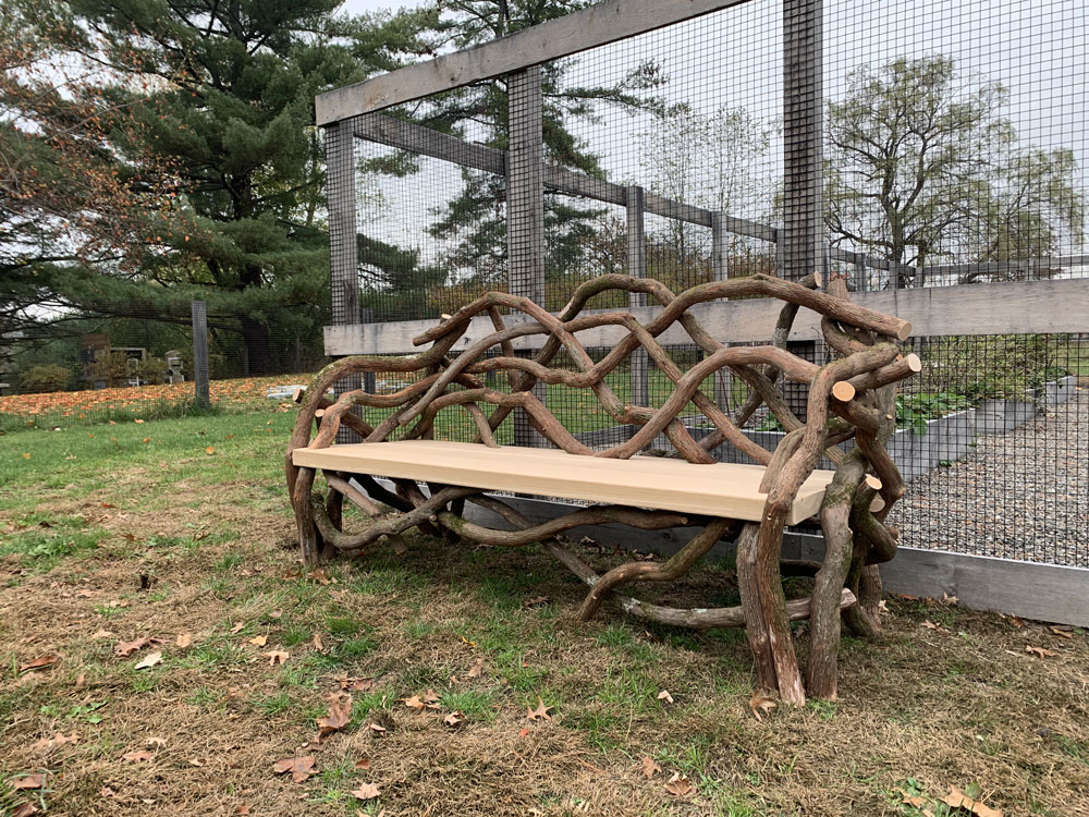 Outdoor rustic park bench built using mountain laurel trees and branches titled the Germantown Olana Benches