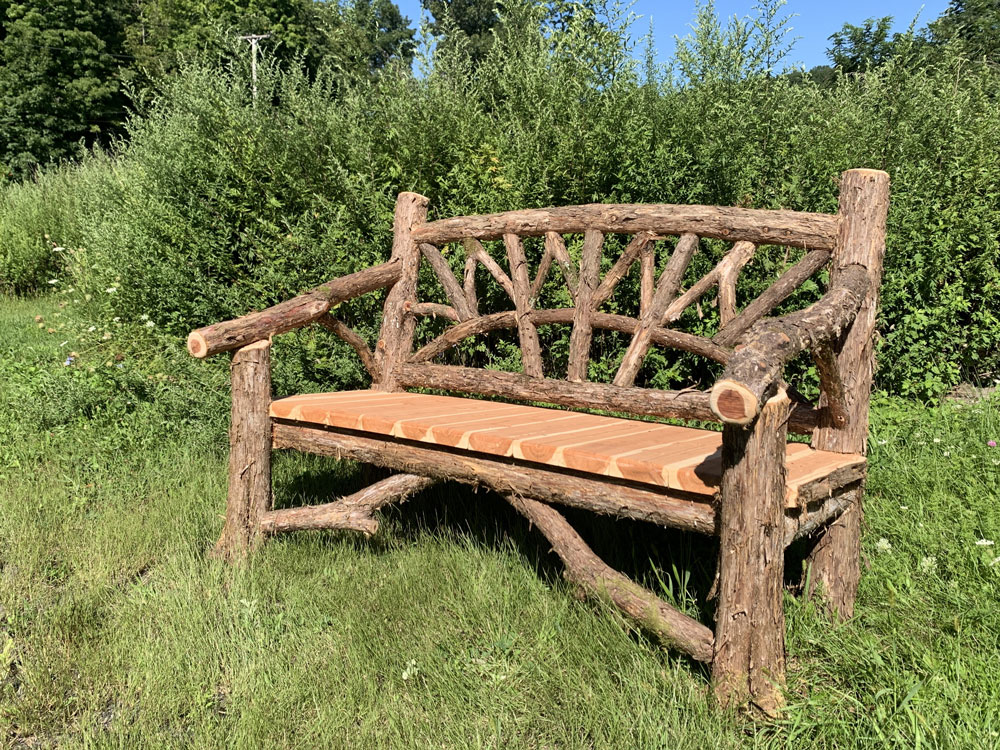 Outdoor rustic garden bench built using bark-on trees and branches titled the Michael Kors Bench