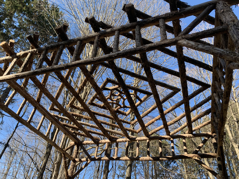 Rustic natural pergola made from bark-on cedar logs, twigs, and branches titled the Staatsburg Pergola