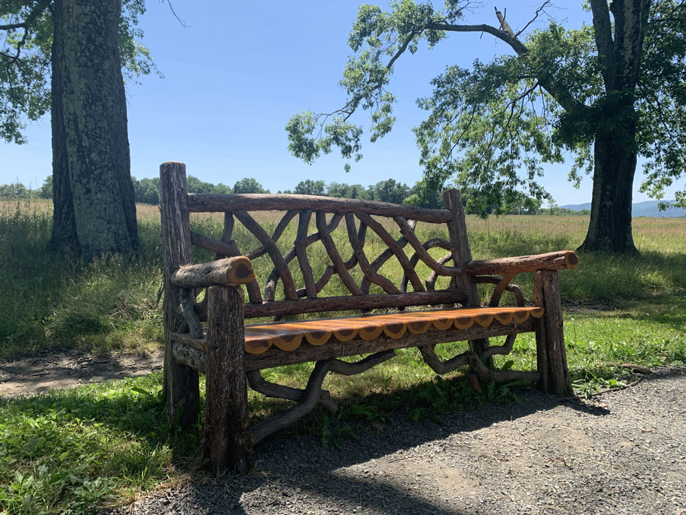 Outdoor rustic garden bench built using bark-on trees and branches titled the Mohonk Bench