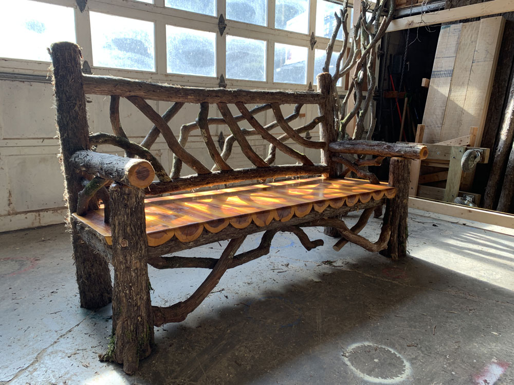 Rustic bench custom built using cedar trees and branches titled the Mohonk Bench