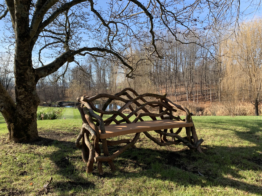 Outdoor rustic park bench built using mountain laurel trees and branches titled the Salgardo Benches