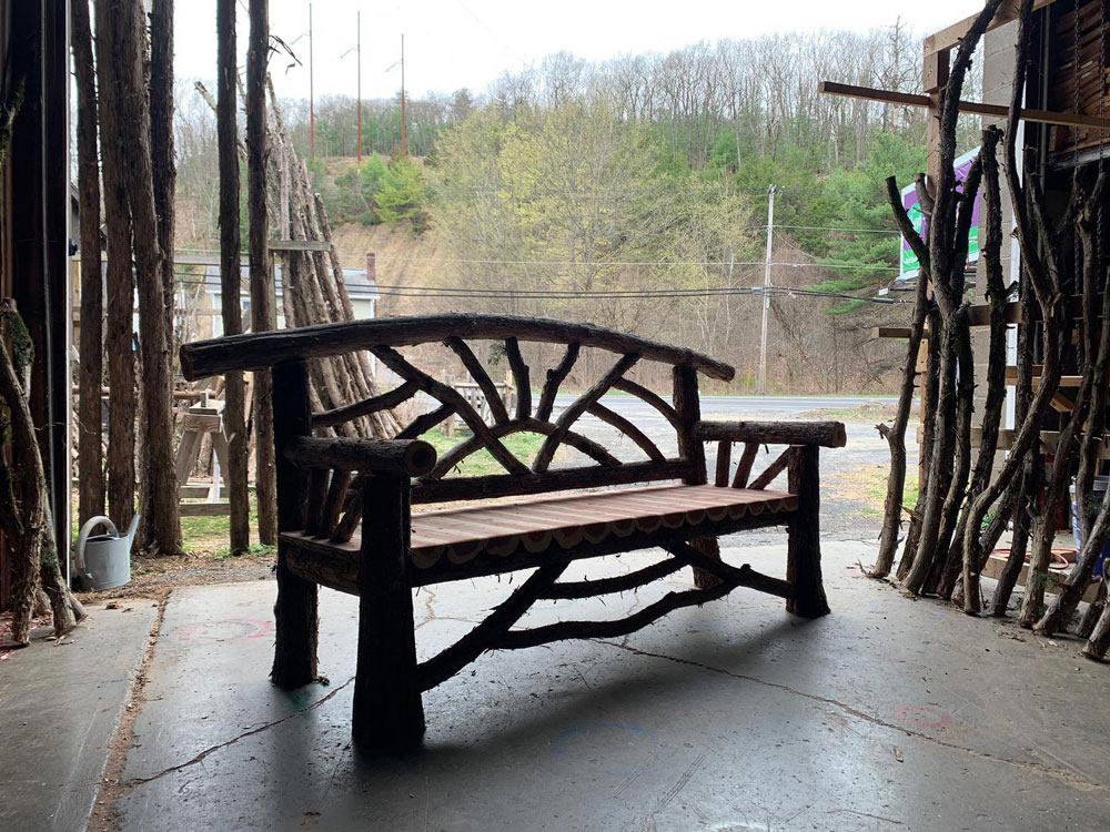 Outdoor park bench built in the rustic style using logs and branches titled the Catskill Butterfly Bench