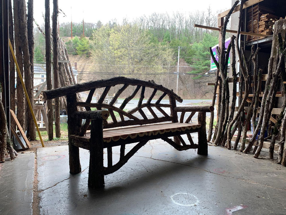 Outdoor rustic garden bench built using bark-on trees and branches titled the Rhinebeck Bench