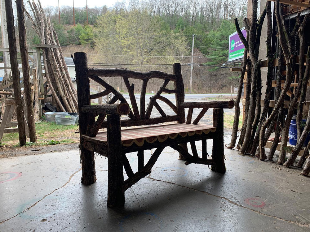 Exterior twig bench built from cedar logs titled the Taconic Bench