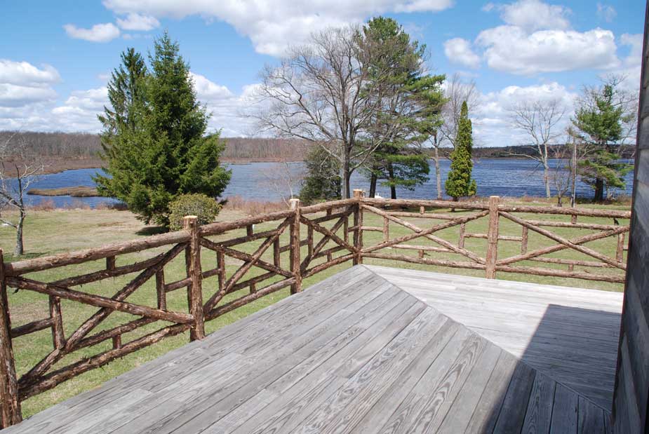 Railings built in the rustic style using logs and branches titled the Huguenot Deck Railings
