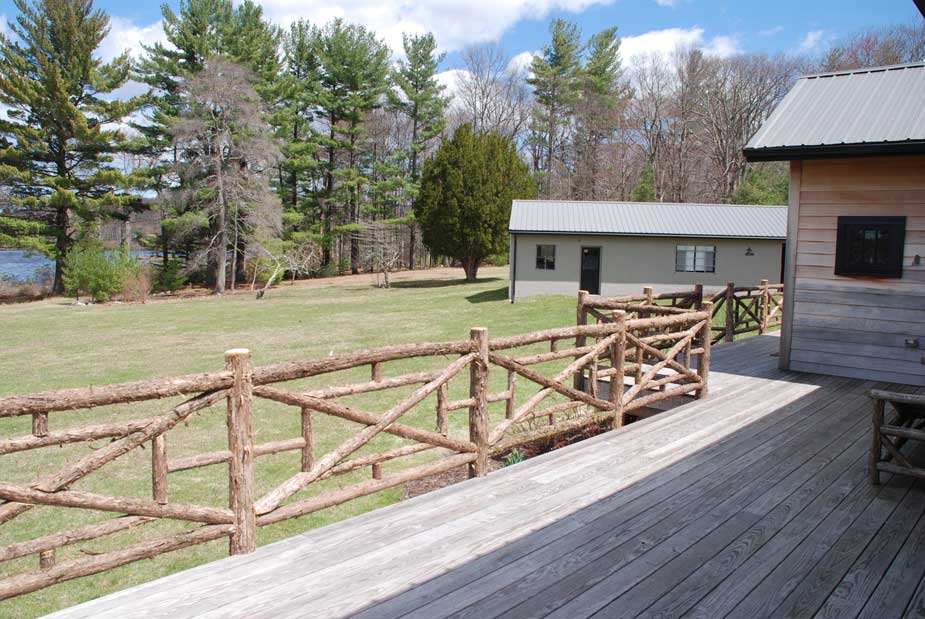 Rustic railings custom built using cedar trees and branches titled the Huguenot Deck Railings