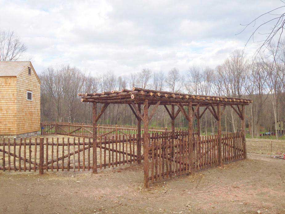 Rustic natural pergola and fencing made from bark-on cedar logs, twigs, and branches at Stonewood Farm
