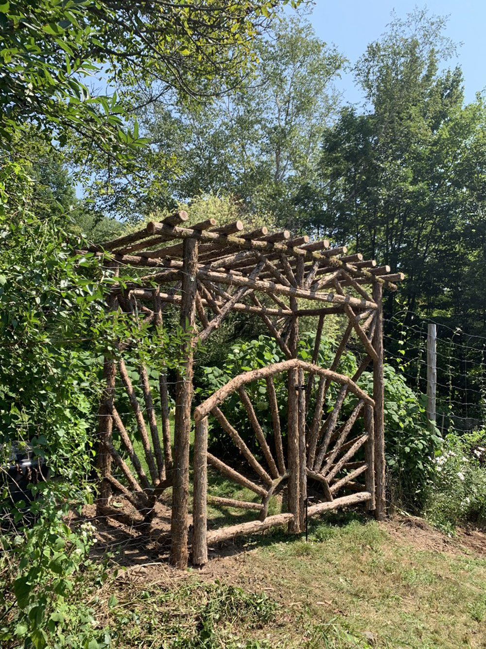 Rustic garden arbor built using bark-on trees and branches titled the Meads Mountain