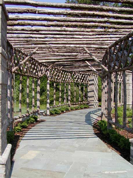 Rustic natural arbor made from bark-on cedar logs, twigs, and branches titled the Pinehurst
